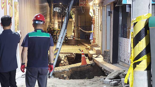 A sinkhole opened on the evening of July 23 at the construction site of an underground parking lot next to a multipurpose government building in Dongdaemun District, eastern Seoul. [YONHAP]