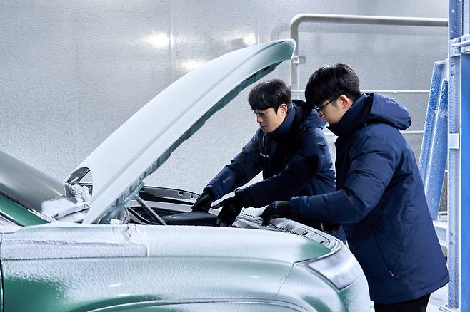 Researchers inspect the frunk of an Ioniq 9 EV, which sits blanketed in snow inside the environmental testing facility, where vehicles are tested under simulated snowfall at Hyundai Motor Group's Namyang R&D Center in Hwaseong, Gyeonggi, on July 23. [HYUNDAI MOTOR]