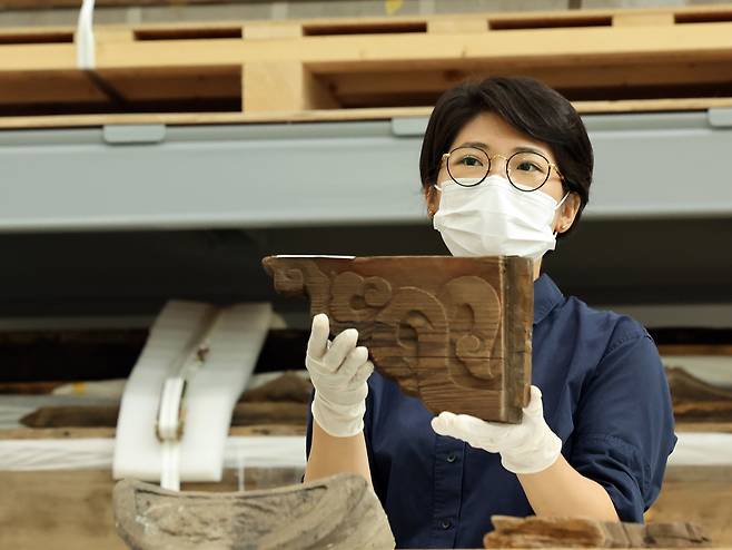 Park So-yeon of the Overseas Korean Cultural Heritage Foundation shows a fragment from the repatriated Gwanwoldang during a press conference at the Traditional Architecture Elements Conservation Center in Paju, Gyeonggi, on July 23. [NEWS1]