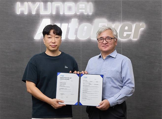 정지훈 현대오토에버 차량전장SW센터장(왼쪽)과  이장섭 DNV 코리아 대표이사가 ASIL-D 인증서를 들고 기념촬영을 하고 있다. [사진 = 현대오토에버]