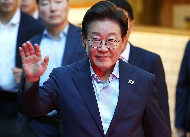이재명 대통령이 7월 11일 저녁 서울 광화문 인근 한식당에서 나오며 시민들에게 손을 흔들고 있다. [연합]