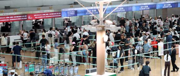 지난 22일 인천국제공항 출국장에서 여름 휴가철을 맞아 출국하는 여행객들이 출국 수속을 밟고 있다. 뉴시스