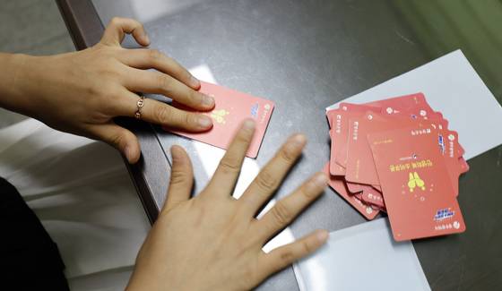 광주시가 민생 회복 소비쿠폰 선불카드의 액수별 '카드 색상'을 다르게 배부해 논란이 인 가운데 24일 광주 한 행정복지센터에서 공직자들이 선불카드에 스티커 부착 작업을 하고있다. 뉴스1