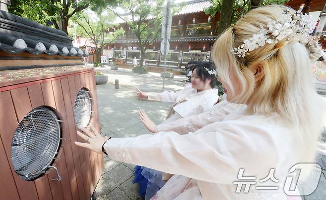 전북 전주시 한옥마을 태조로에서 관광객들이 쿨링포그 앞에서 더위를 식히고 있다. 2025.7.14/뉴스1 ⓒ News1 유경석 기자