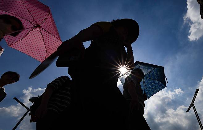 한 시민이 양산을 쓰고 이동하고 있다./연합뉴스