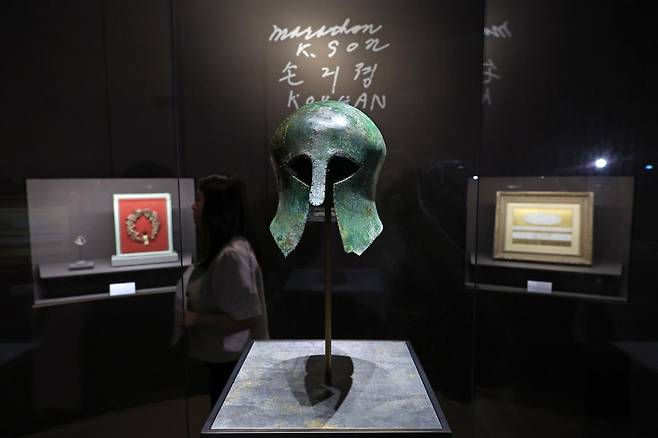 손기정 선수가 1936년 독일 베를린 올림픽 마라톤 우승 부상으로 받은 보물 ‘청동 투구’가 서울 용산구 국립중앙박물관 특별전에 전시돼 있다. 뒤편으로 손 선수가 ‘Korean 손긔졍’이라고 서명한 엽서에서 따온 글씨가 보인다. 뉴시스