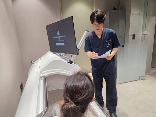 연세우주이비인후과 고압산소치료실에서 한 질환자가 치료를 받으면서 남우주 원장의 설명을 듣고 있다. 사진=연세우주이비인후과 제공