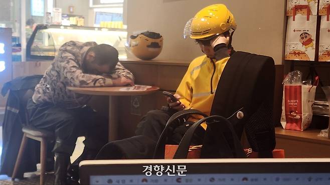 중국 배달 플랫폼 메이퇀 소속 배달원이 베이징의 백화점 카페에서 엎드려 자면서 휴식을 취하고 있다./박은하 기자.