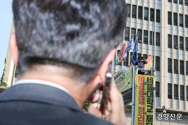 김영훈 고용노동부 장관이 25일 서울 중구 세종호텔 앞 농성장을 찾아 정리해고 철회 등을 촉구하며 163일째 고공농성 중인 고진수 민주노총 세종호텔 지부장과 전화통화를 하고 있다. 성동훈 기자