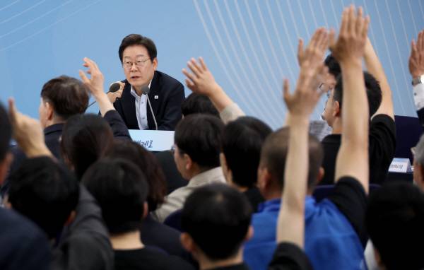 25일 부산 부경대에서 이재명 대통령이 참석한 가운데 열린 타운홀미팅 ‘부산의 마음을 듣다’ 간담회에서 시민들이 손을 들어 발언권을 요청하고 있다. 연합뉴스