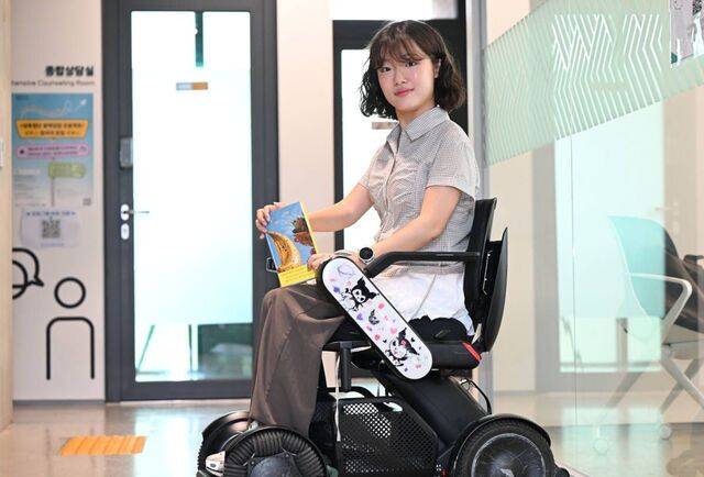 유튜버 ‘굴러라 구르님’으로 활동 중인 김지우씨가 지난 15일 서울청년센터 성북에서 최근 출간한 책 ‘의심 없는 마음’을 들고 포즈를 취하고 있다. 휠체어에 그려진 인기 캐릭터 쿠로미는 ‘휠꾸’(휠체어 꾸미기)를 좋아하는 김씨가 직접 그린 그림이다. 최현규 기자