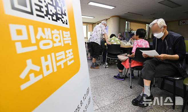 [수원=뉴시스] 김종택 기자 = 정부의 민생회복 소비쿠폰 1차 신청 첫날인 지난 21일 경기 수원시 행궁동 행정복지센터에서 시민들이 지원금을 신청하기 위해 대기하고 있다. 2025.07.21. jtk@newsis.com