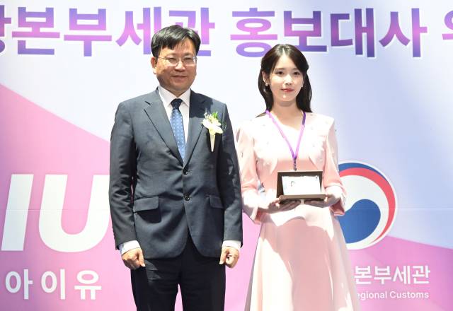 아이유(IU·본명 이지은)가 25일 인천국제공항 제1터미널에서 열린 인천공항본부세관 홍보대사 위촉식에서 김종호 세관장에게 위촉패를 받은 뒤 기념 촬영을 하고 있다. 영종도=오승현 기자 2025.07.25