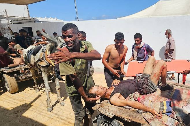 지난 7월 12일(현지시간) 미국과 이스라엘이 지원하는 ‘가자 인도주의 재단(GHF)’의 배급소에 식량을 구하러 갔다가 이스라엘군의 총격을 받은 팔레스타인 피해자들이 가자지구 남부 라파의 적십자 병원으로 이송되고 있다. AFP연합뉴스