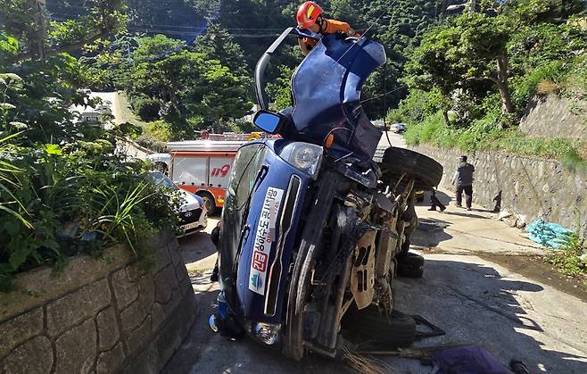 울릉도에서 자동차 전복사고가 발생, 119구조대원이 동승자를 구출하고 있다. /울릉119안전센터 제공