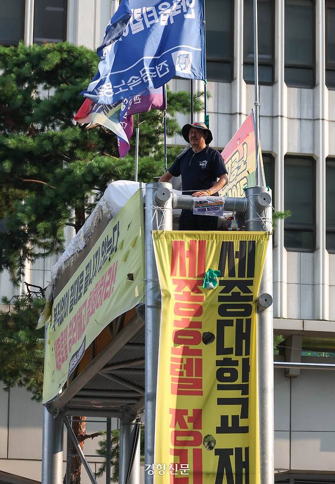 정리해고 철회 등을 촉구하며 163일째 고공농성을 하고 있는 고진수 민주노총 세종호텔 지부장이 25일 서울 세종호텔 앞 고공농성장에서 김영훈 고용노동부 장관과 전화통화를 하기 위해 기다리고 있다. 성동훈 기자