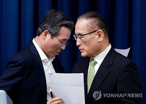 김용범 대통령실 정책실장(왼쪽)과 위성락 국가안보실장이 25일 서울 용산 대통령실 청사에서 이날 강훈식 대통령비서실장 주재로 열린 통상대책회의 관련 브리핑에 대한 취재진의 질문에 답하기 위해 마이크 앞 자리를 바꾸고 있다. 연합뉴스