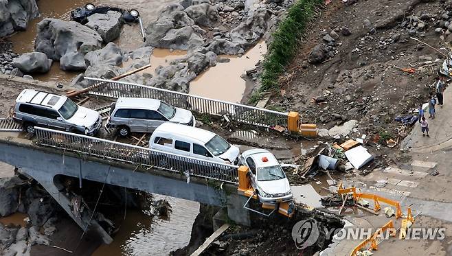 2007년 9월 태풍 나리 당시 붕괴된 제방과 찌그러진 자동차 [연합뉴스 자료사진]