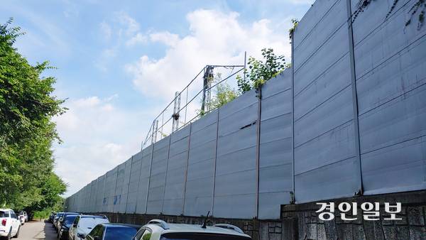 높은 담장으로 둘러싸여 외부와 철저하게 차단된 안양시 석수동 연현마을 인근 아스콘공장. 담장을 낀 좁은 길에는 무질서하게 주차된 차량들이 가득하다. 2025.7.23 안양/박상일기자 metro@kyeongin.com