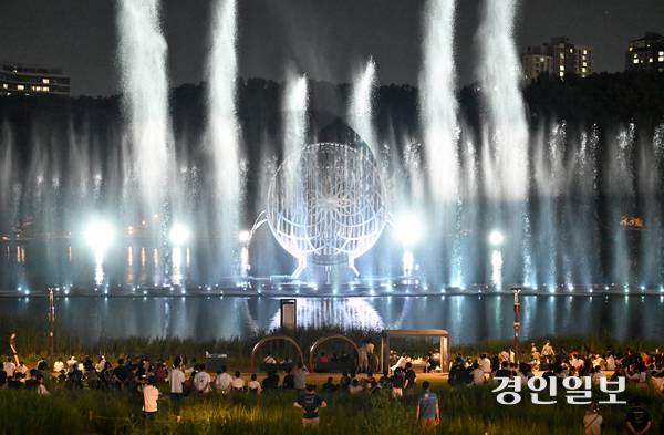 연일 폭염과 열대야가 이어지는 가운데 지난 26일 저녁 화성시 동탄호수공원에서 시민들이 멀티미디어 분수 쇼인 ‘루나쇼’를 보며 더위를 식히고 있다. 2025.7.26 /최은성기자 ces7198@kyeongin.com