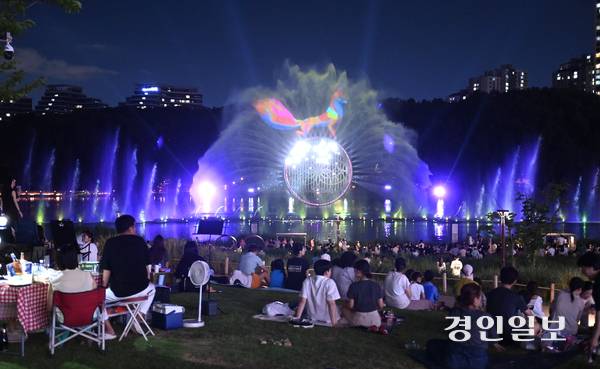 연일 폭염과 열대야가 이어지는 가운데 지난 26일 저녁 화성시 동탄호수공원에서 시민들이 멀티미디어 분수 쇼인 ‘루나쇼’를 보며 더위를 식히고 있다. 2025.7.26 /최은성기자 ces7198@kyeongin.com