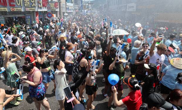 제18회 정남진 장흥물축제가 지난 26일 장흥 탐진강 수변공원 일원에서 열린 가운데 크란 공연팀과 아프리카 타악 퍼포먼스팀 아냐포의 중앙로 시가지 거리 퍼레이드와 함께 내외국인들이 물싸움을 하며 폭염을 날리고 있다. 김양배 기자