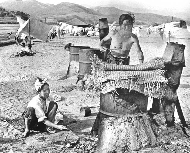 1955년 여름날 팔달교 아래 금호강 백사장에서 아낙네들이 드럼통을 잘라 만든 가마솥에 빨랫감을 삶고 있다. 매일아카이빙센터