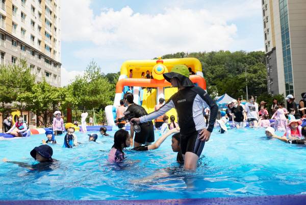 26일 칠곡군 왜관읍의 태왕아너스 센텀 아파트 단지에 주민들이 힘을 모아 10m 길이의 수영장 두 개를 설치했다. 사진은 물놀이를 즐기는 아이들을 지켜보는 대학생 안전요원 모습.