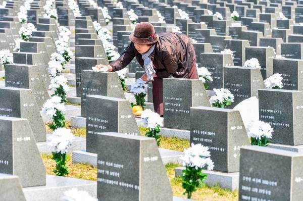 제주4.3평화공원 내 행방불명인 묘역에서 한 유족이 비석(표지석)을 닦고 있다.