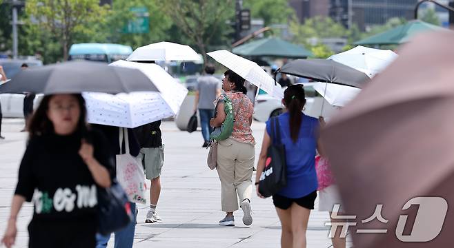 서울 종로구 광화문광장에서 외국인 관광객들이 양산을 쓴 채 발걸음을 옮기고 있다. /뉴스1 ⓒ News1 김성진 기자