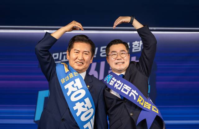 더불어민주당 대표 선거에 출마한 정청래(왼쪽)·박찬대 의원이 지난 19일 중앙당사에서 열린 합동연설회에서 함께 손하트를 만들고 있다. [더불어민주당 제공]