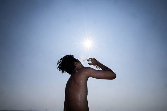 전국 대부분 지역에 폭염특보가 발효된 25일 오후 인천광역시 중구 하나개해수욕장에서 피서객이 얼굴에 물을 뿌리며 더위를 달래고있다. 최기웅 기자