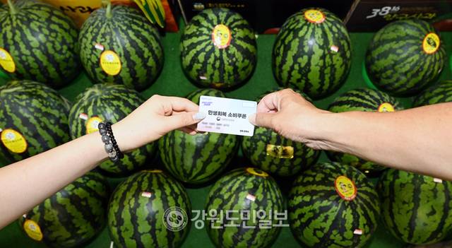 ▲ 소비자심리지수가 4년 만에 최고치를 기록한 가운데 24일 춘천 후평동의 한 시장에서 시민이 민생회복 소비쿠폰을 이용해 수박을 구매하고 있다. 김정호 기자