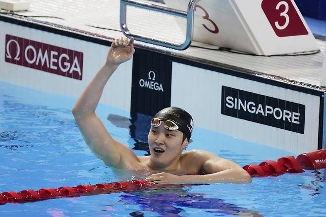 김우민이 27일 싱가포르에서 열린 세계수영선수권대회 남자 자유형 400ｍ에서 3위로 터치패드를 찍은 뒤 기록을 확인하고 기뻐하고 있다. 싱가포르 | AP연합뉴스