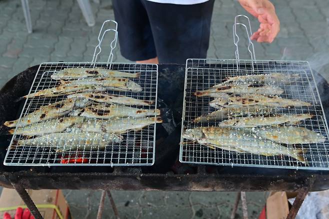 봉화은어축제장을 찾은 관광객들이 갓잡은 은어를 숯불에 익히고 있다. 봉화군 제공