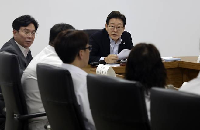 이재명 대통령이 25일 경기 시흥시 SPC 삼립 시화공장에서 열린 산업재해 근절 현장 노사간담회에서 SPC 삼립 직원의 발언을 듣고 있다. 이 대통령 왼쪽은 김영훈 고용노동부 장관. 연합뉴스