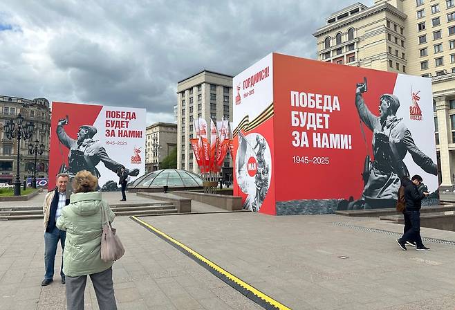 러시아 모스크바 붉은광장 인근에 설치된 전승절 80주년 기념물 앞에서 행인이 기념 촬영을 하고 있다. [연합]