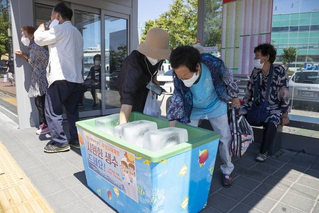 ▲전북 익산시가 폭염 대응 종합대책 일환으로 버스 승강장 28개소에 비치한 대형 얼음 및 생수를 통해 시민들이 더위를 식히고 있다. ⓒ익산시