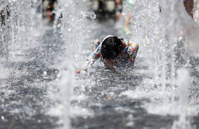 폭염이 이어지고 있는 27일 서울 광화문광장 분수대에서 어린이가 물놀이를 하고 있다. 연합뉴스