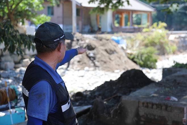 하천 범람한 곳을 가리키는 최근춘(65)씨 [촬영 심민규]