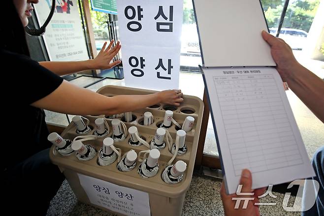 폭염이 이어진 28일 오전 대구 달서구청 직원들이 민원실에서 양산꽂이 앞에 '양심양산' 안내문을 붙이고 있다. '양심에 맡기자'는 취지로 빌려주는 이 양산은 이용자가 관리대장을 작성하지 않는 경우가 많아 회수율이 낮다. 2025.7.28/뉴스1 ⓒ News1 공정식 기자