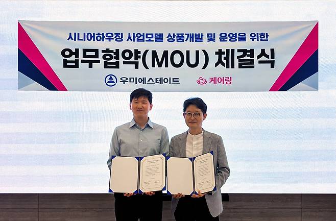 우미에스테이트와 케어링의 시니어하우징 사업모델 개발 및 운영을 위한 전략적 업무협약식을 마친 뒤 김태성 케어링 대표(사진 왼쪽)와 김병권 우미에스테이트 대표가 기념 촬영하고 있다. /우미건설 제공