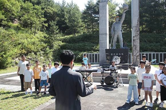 김대중 교육감과 청풍초 학생들이 화순탄광 광부동상 앞에서 합장을 하고 있다.  [사진=전남도교육청]