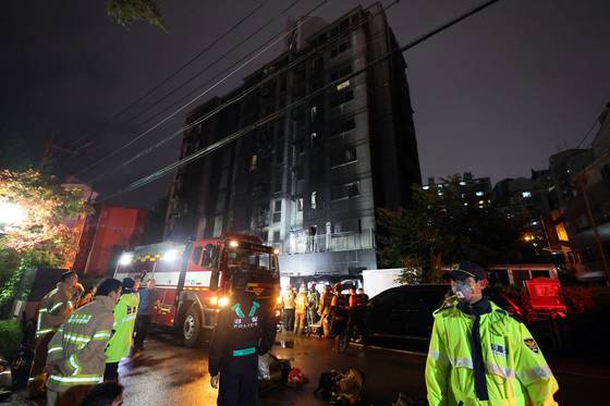 소방대원이 17일 주차장에 불이 난 경기도 광명시 소하동 한 아파트에서 인명 수색하는 가운데 경찰이 현장을 통제하고 있다. 연합뉴스