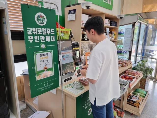 군위군청점 로컬푸드 판매장에서 한 민원인이 '민생회복 소비쿠폰'을 사용하고 있다 군위군 제공
