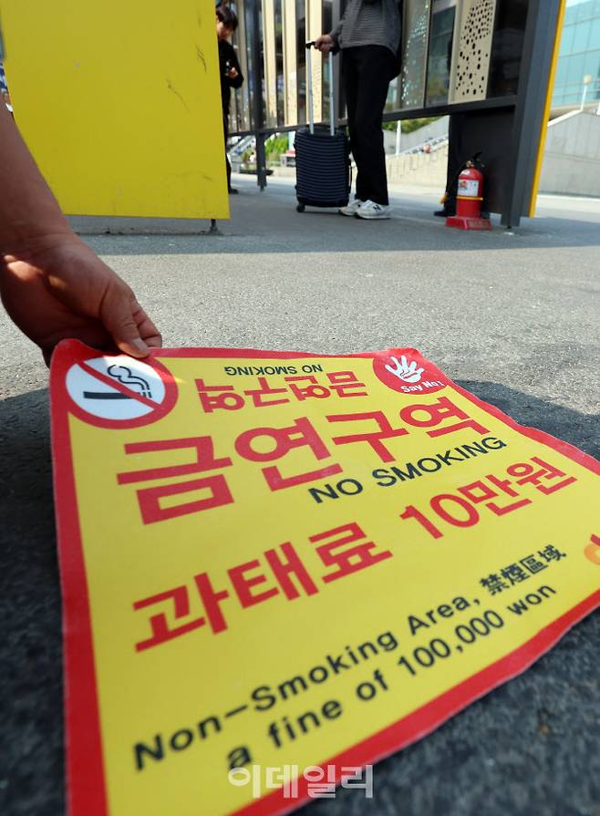 지난 6월 1일 오전 서울역광장에서 중구청 관계자들이 ‘금연구역’ 안내 스티커를 붙이고 있다. 이날부터 서울역광장과 인근 도로 약 5만7000㎡가 금연구역으로 지정되며 흡연시 10만원의 과태료가 부과된다. (사진=뉴스1)