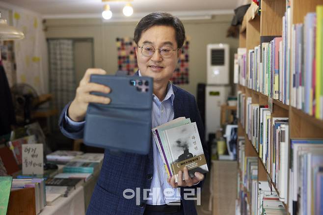 29일 오후 수원시 장안구 광화문서림 서점에서 책을 구매한 김동연 경기도지사가 구매 인증샷을 찍고 있다.(사진=경기도)