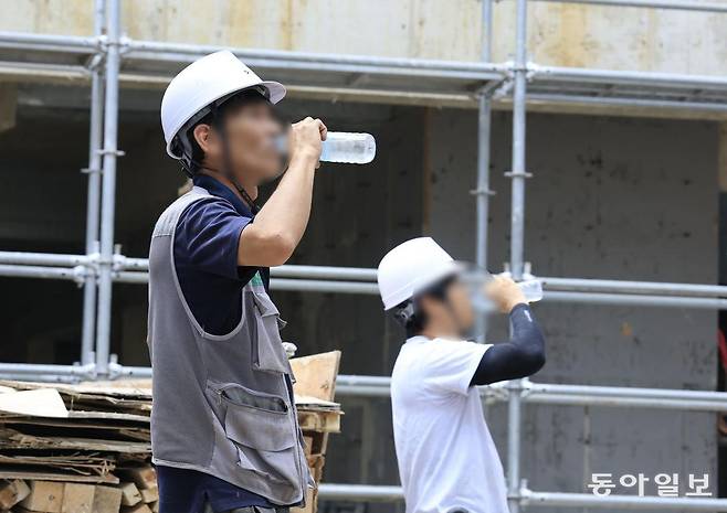 광주 북구 소재 건설 현장에서 안전모를 쓴 근로자들이 작업을 잠시 중단한 채 물을 마시며 더위를 식히고 있다. 광주=박영철 기자 skyblue@donga.com