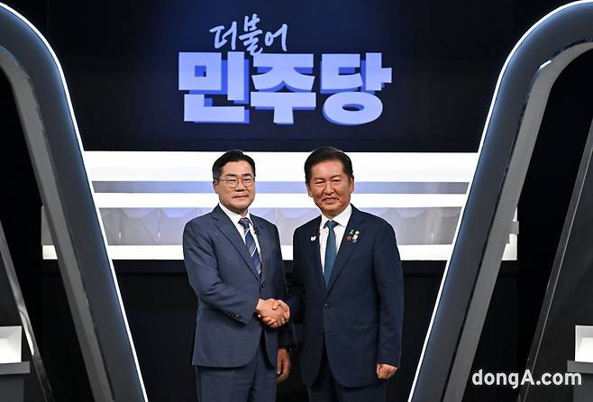 정청래(오른쪽)·박찬대 더불어민주당 당 대표 후보(기호순)가 악수를 하면서 기념사진을 촬영하고 있다. 뉴시스.