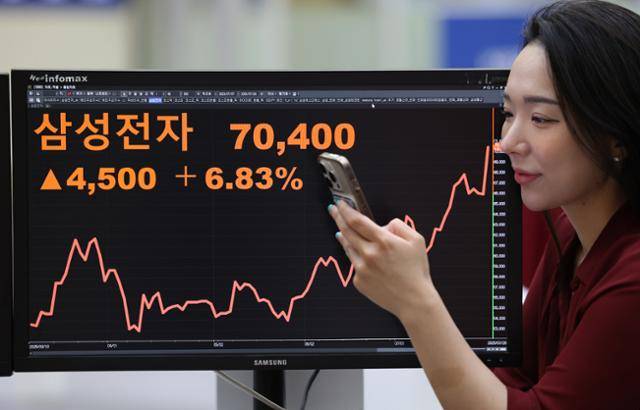 삼성전자가 23조원에 달하는 반도체 위탁생산 계약 소식에 11개월 만에 7만원선을 돌파한 28일 서울 여의도 한국거래소 서울사무소에 삼성전자 주가가 표시돼 있다. 뉴시스